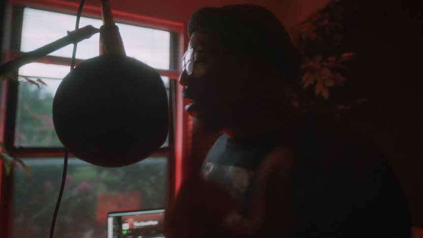 A man records himself rapping in a studio