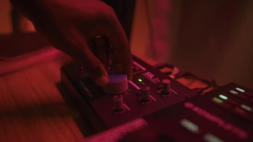 A man turns a dial next to a keyboard
