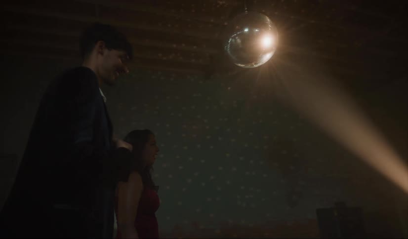 A couple walk under the disco ball