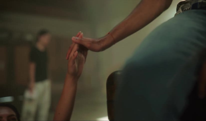Two friends hold hands as someone skateboards