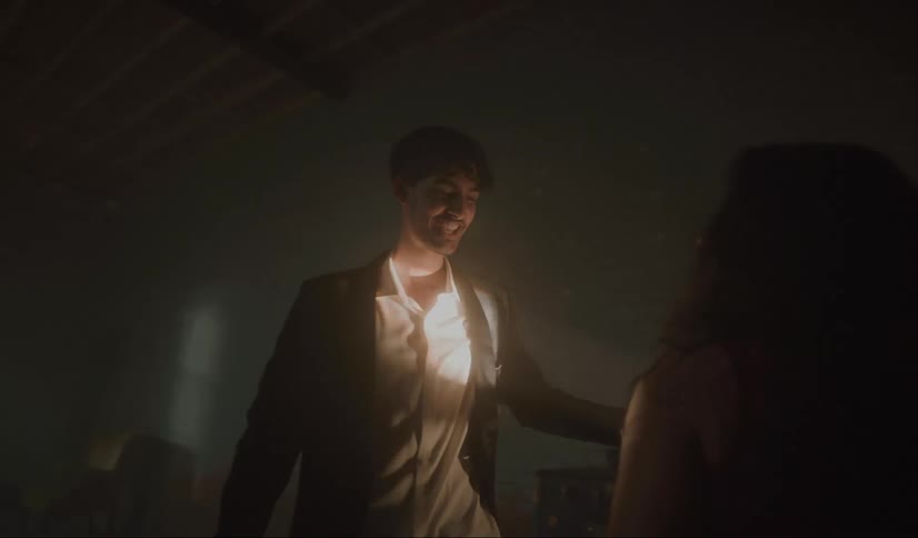Couple dance in dim room lit by mirror ball and a spotlight
