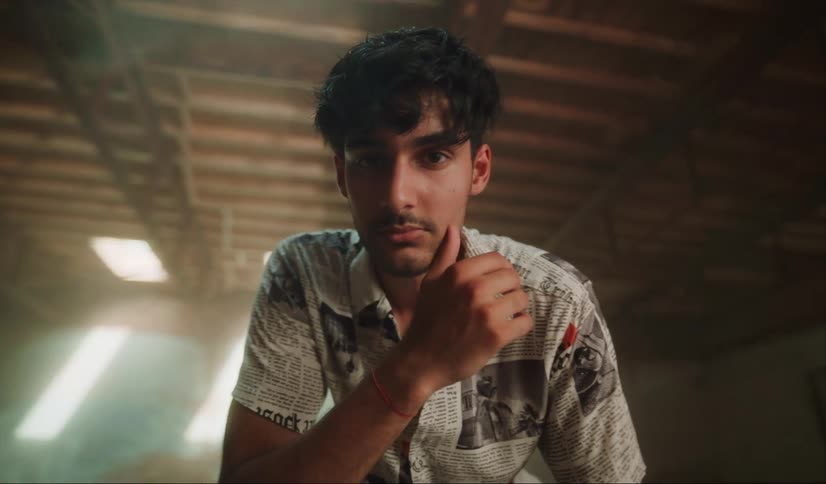 Young good looking man stands on an empty abandoned warehouse looking at the camera