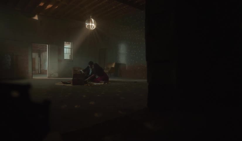 A man and woman sit on the floor in an empty room in a house