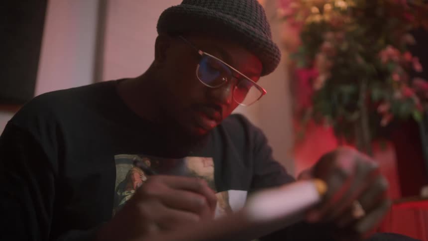 A man bops his head as he writes song lyrics