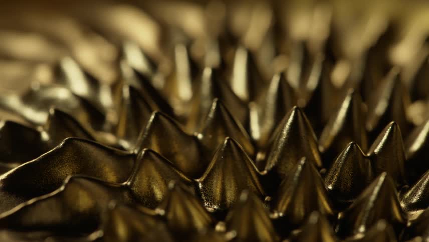 A shiny liquid gold substance moves and spikes emerge and they bend and go back down
