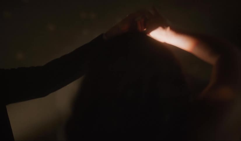 A young man twirls his girlfriend as they slow dance with lights glowing