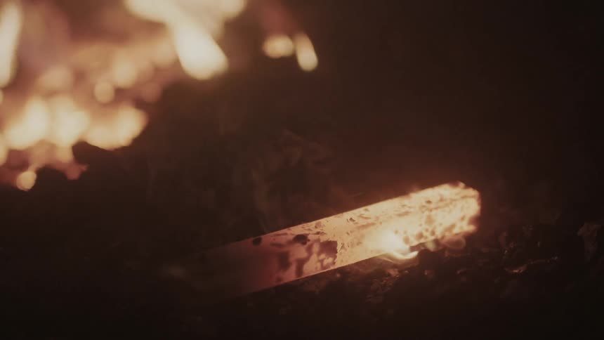 Flames licking at a piece of red-hot iron