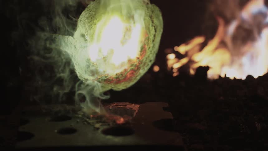 A blacksmith pouring molten iron into a mold
