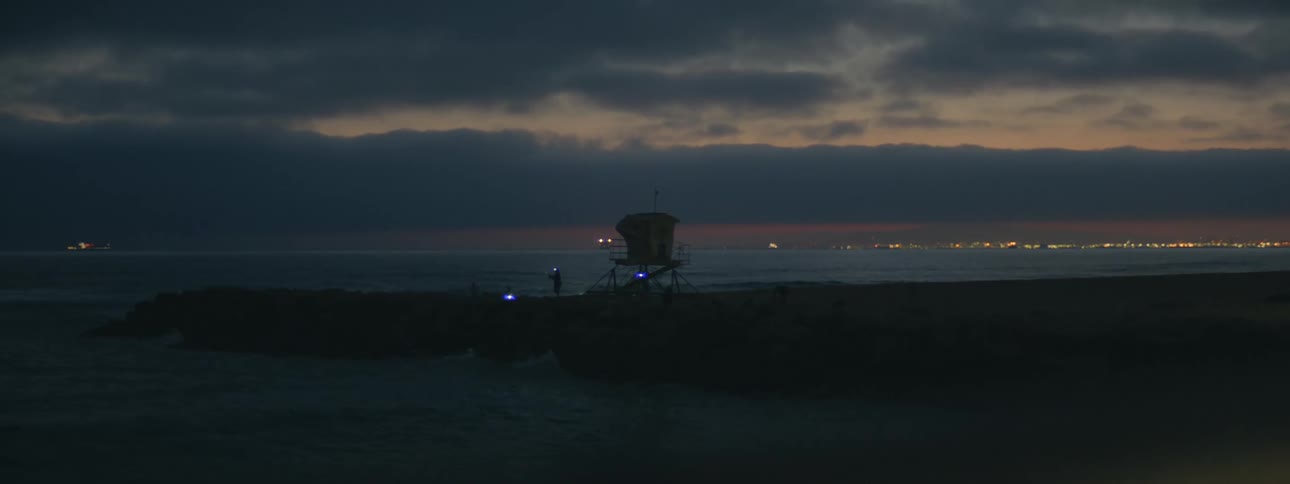 Lights flicker around a lifeguard tower on the beach