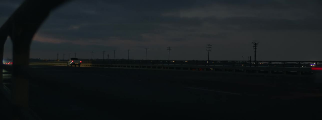 Vehicles driving down a street at night