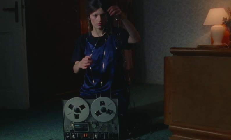 A woman is trying to fix the old film machine