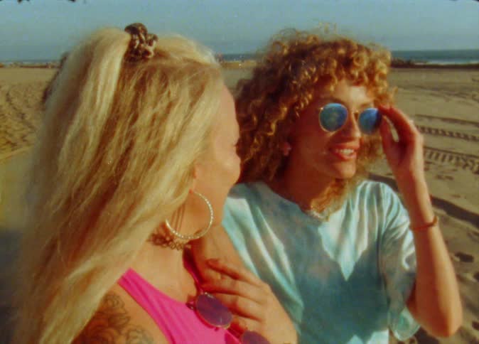 Two friends talk on the beach