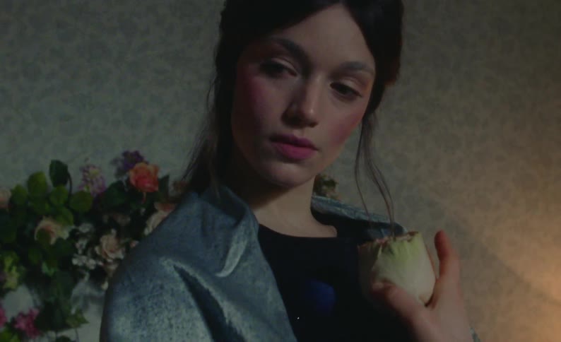 A model is posing with a flower
