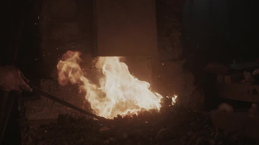 A blacksmith holding something in a fire