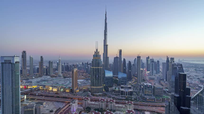 Time lapse of the tall skyscrapers on the skyline of dubai from daylight to night