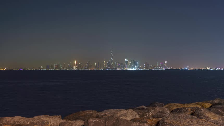 City skyline with modern illuminated skyscrapers on the horizon at night