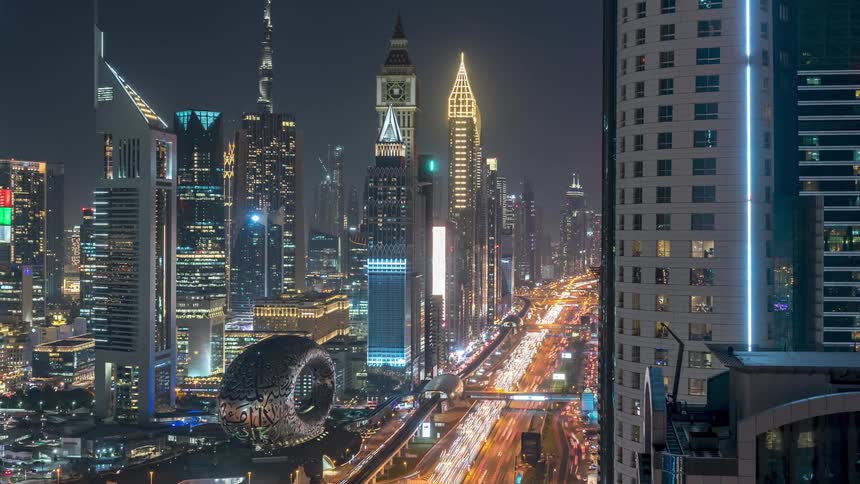 Heavy traffic travels through a bustling city at night