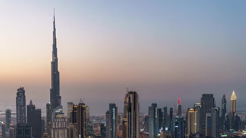 The burj khalifa standing above the dubai skyline leading a colorful light show at night