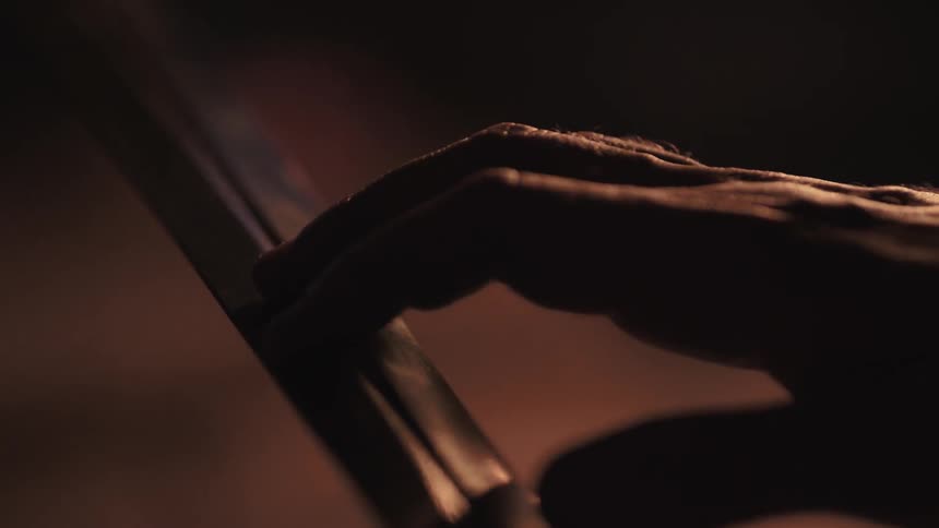 A hand traces along a sword