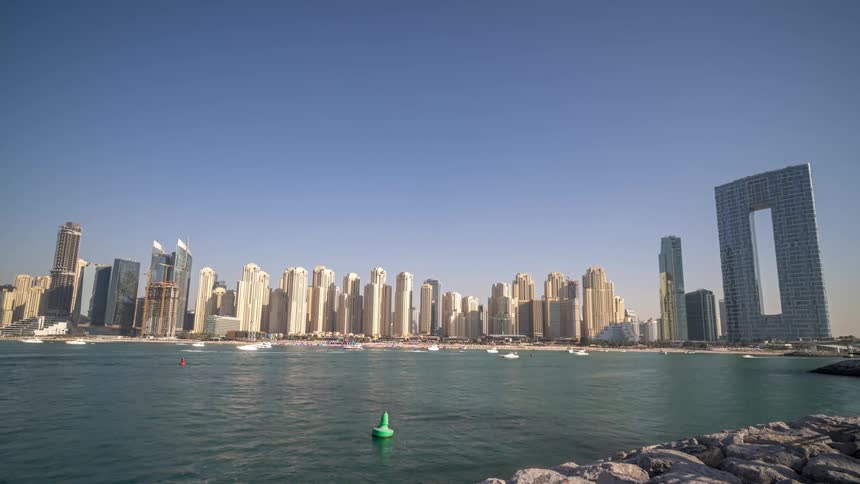 Boats sail speed through the ocean as they pass downtown