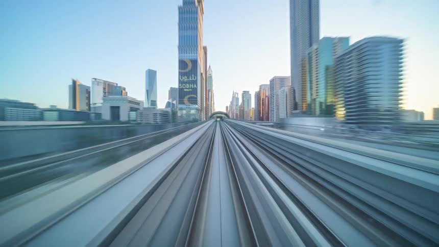 Passenger train tracks parallel the coast as they move through city