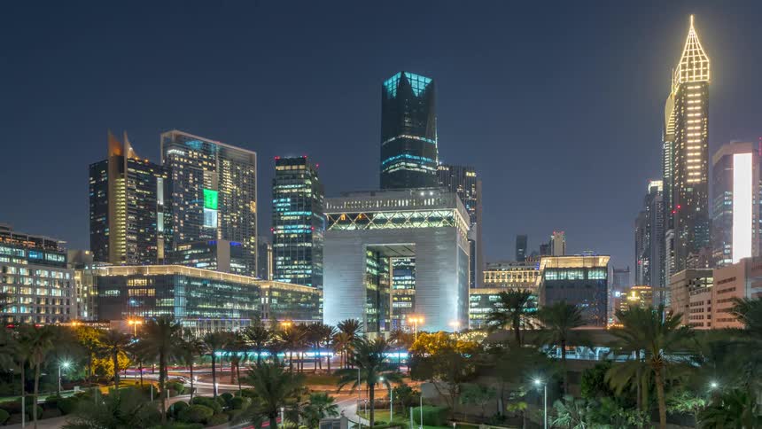 Traffic moves along downtown city streets as day turns to night