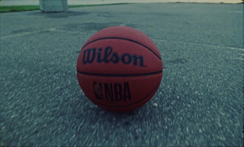 Basketball rolls across basketball court