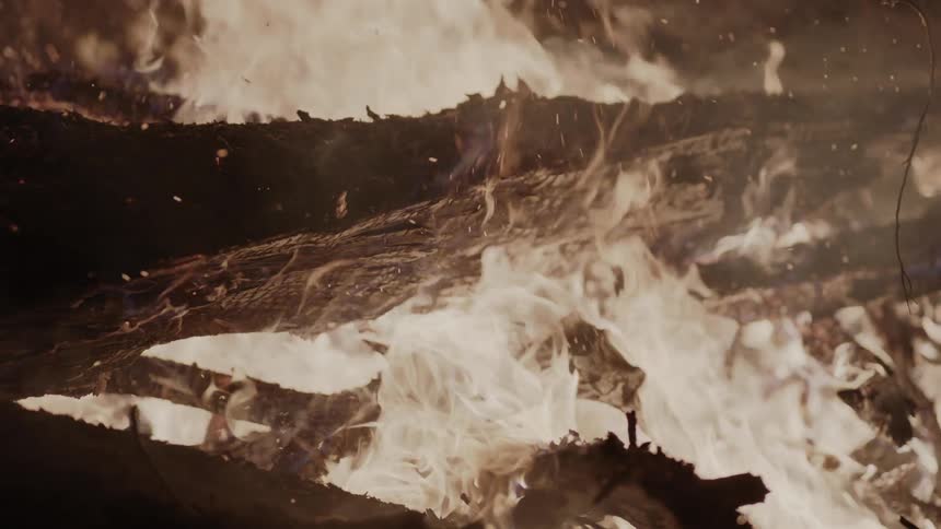 A large fire is burning at night