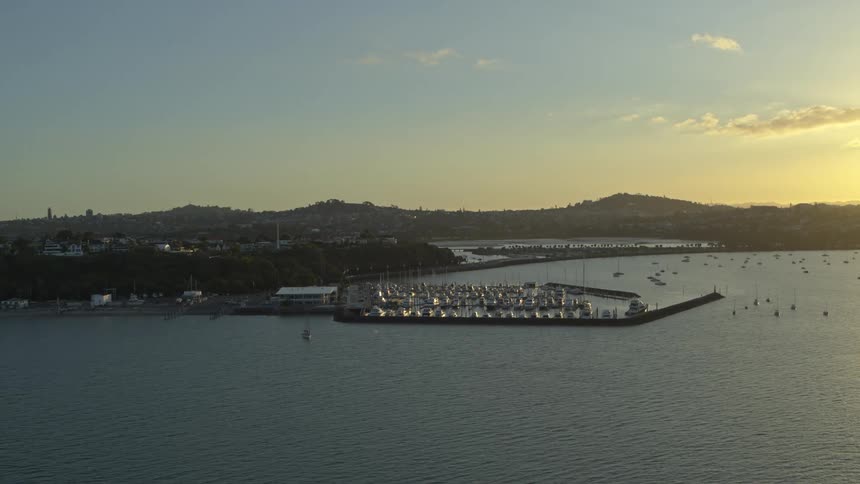 Boats sail around a marina near a neighborhood