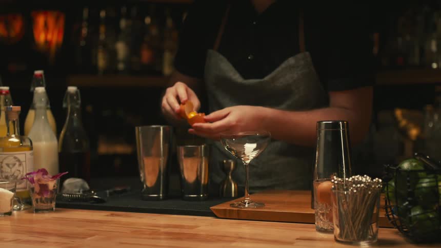 A bartender preparing a drink at a bar counter