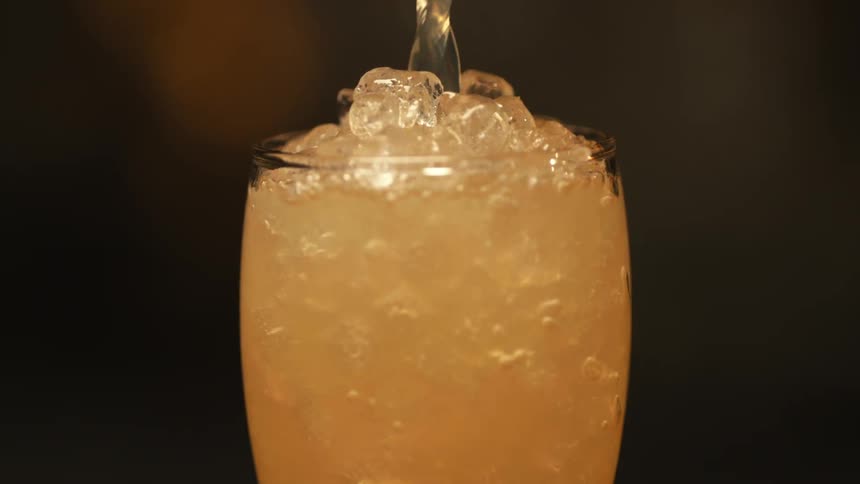 Someone is pouring a drink into a glass