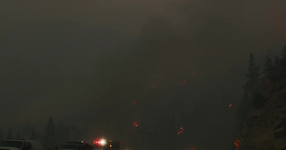 An ambulance and first responders at the scene of a forest fire