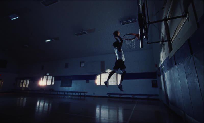 A man is playing basketball by himself