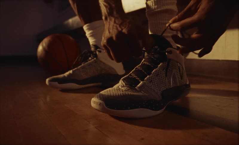 A man is tying his shoes indoors during the day