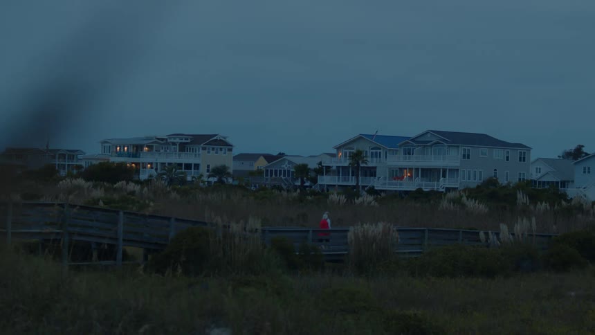 A person is walking toward the row of homes