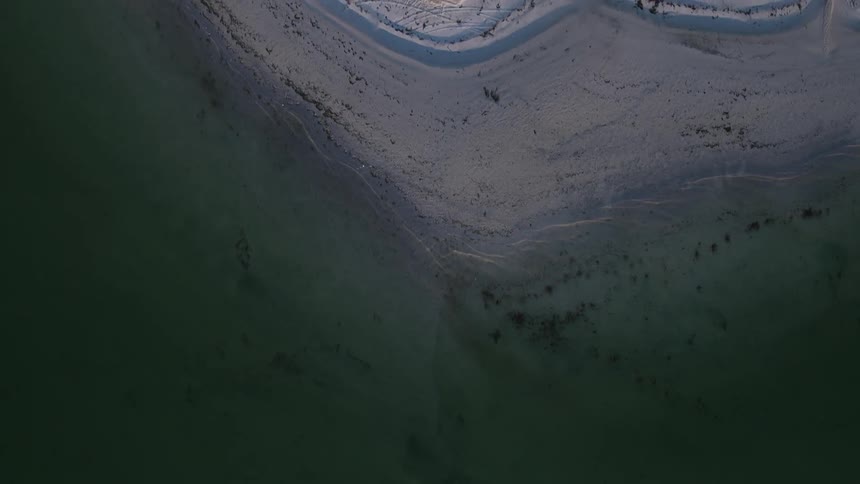 Waves of water that go ashore at the sandy beach