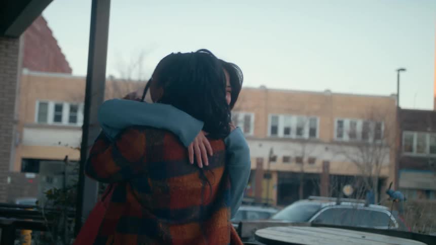 Two friends greet each other and hug