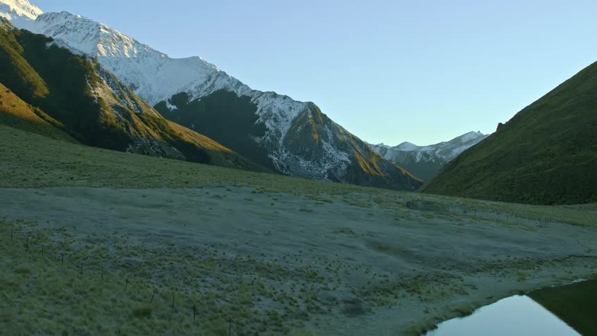A calm lake and snowy mountains in nature in pre dawn light