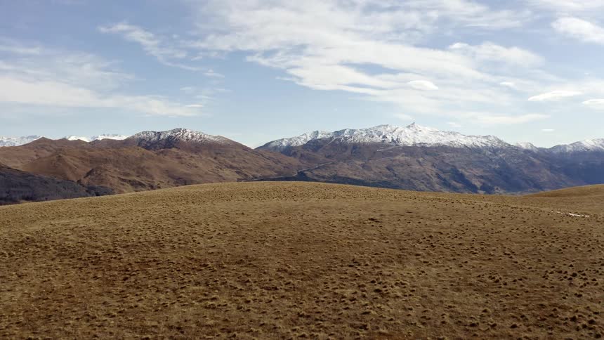 Native tussock grassland with mountains covered with snow at the top