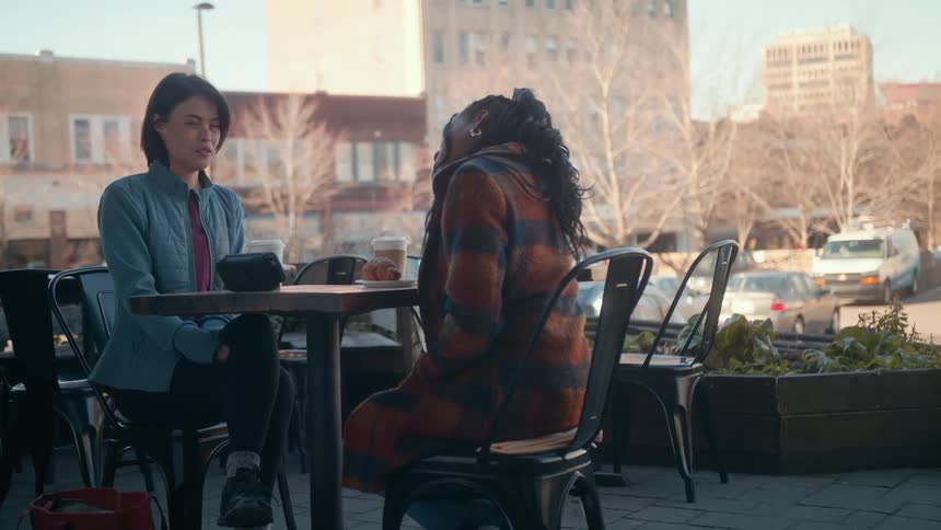 Two women talk outside at a restuarant