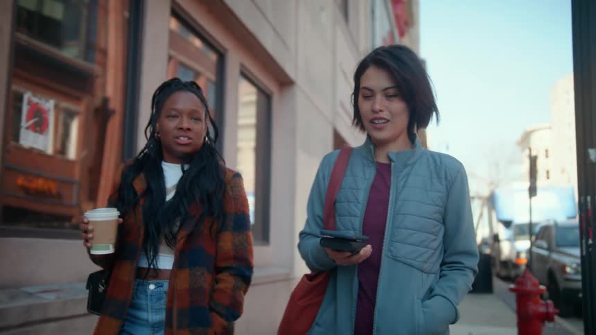 Two people walk down the sidewalk together