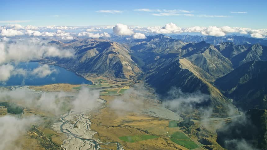 Clouds floating above mountains and lake in natural New Zealand
