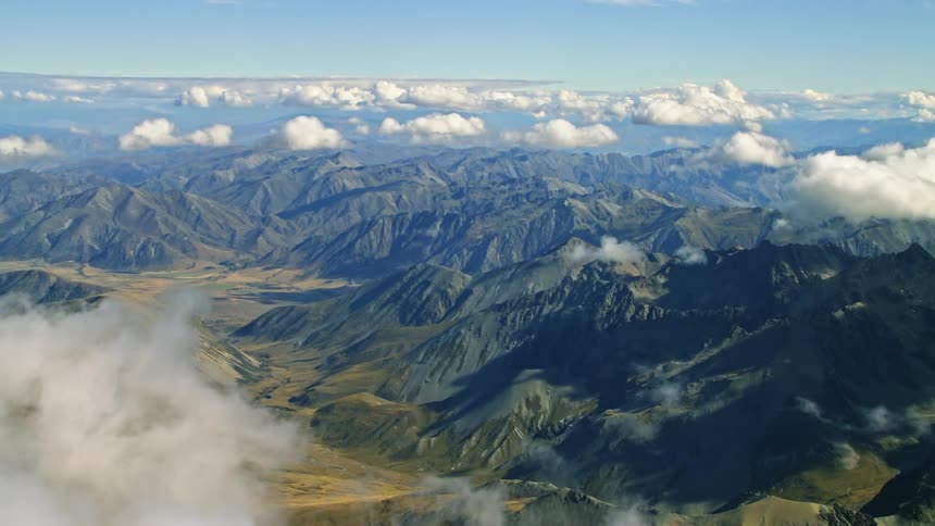 Aerial view of high mountain range under the clouds floating