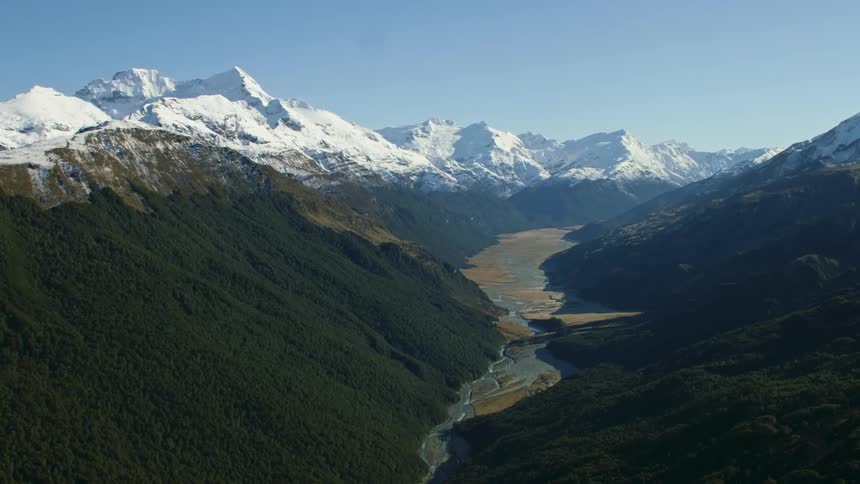 The river runs through the mountain peaks and native forest