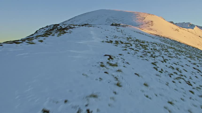 Low level track along mountain with snow and alpine native grasses