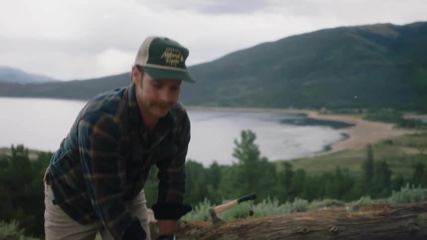 A man cutting wood while camping