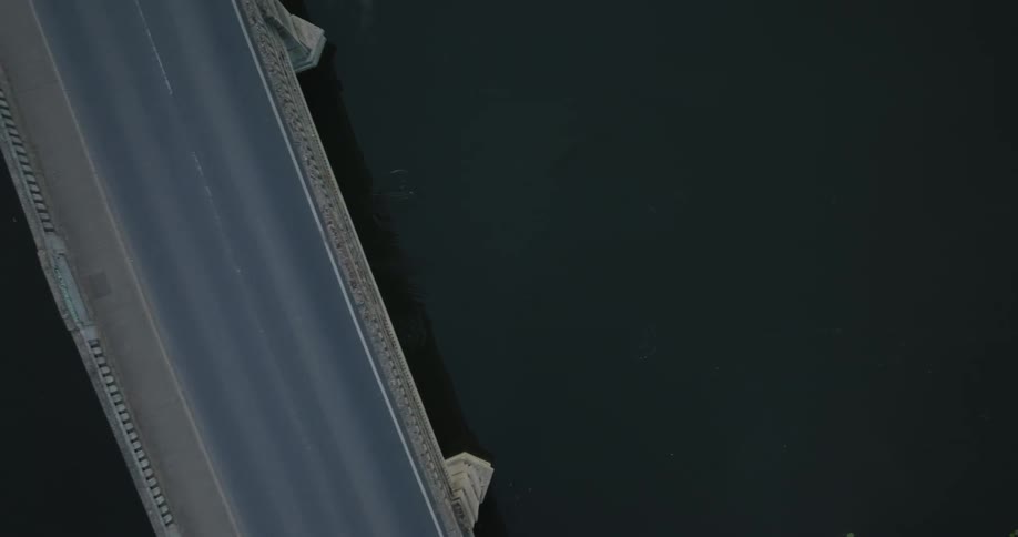 A person rowing a boat beneath a bridge
