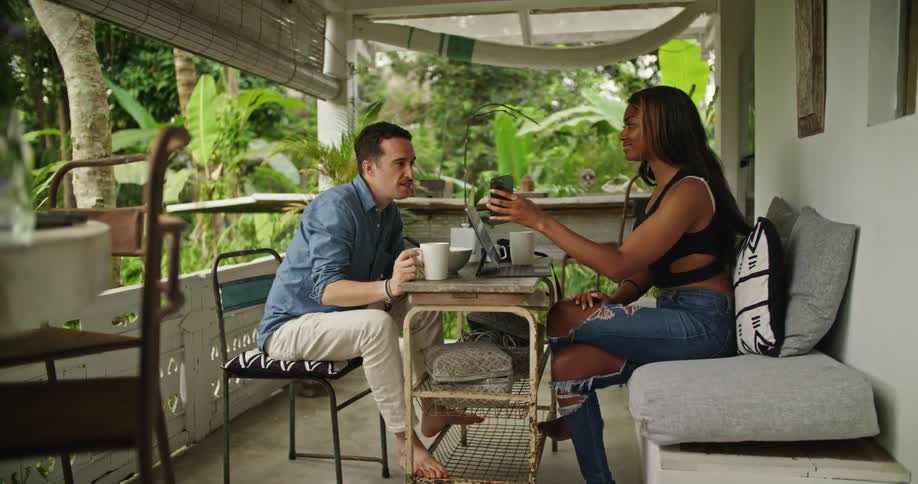 Man and woman are sitting outdoors together and talking