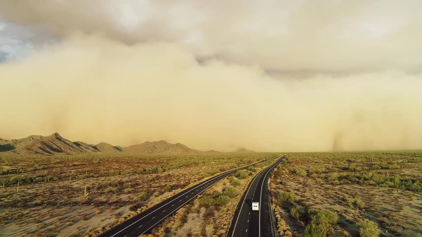 Giant wall of dust travels toward moving vehicles on highway