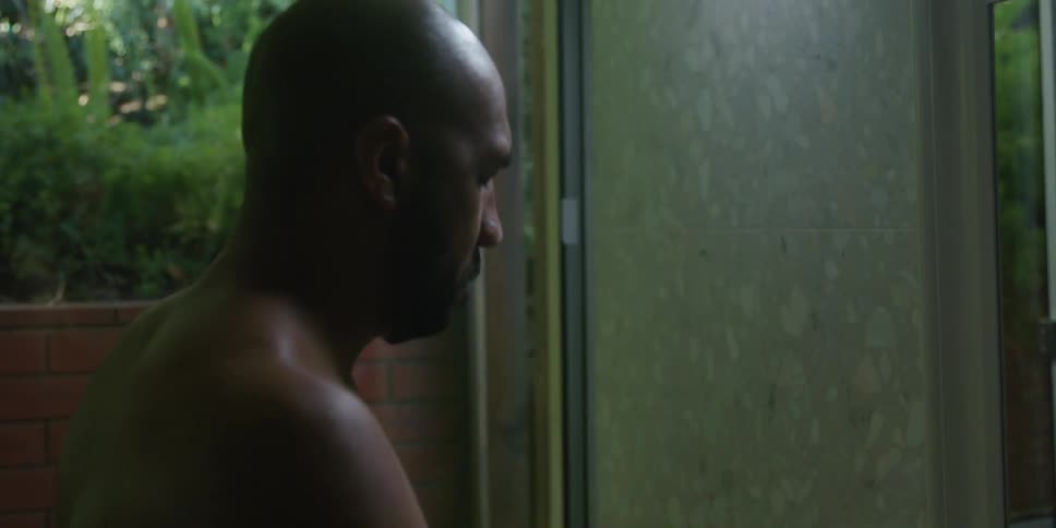 A man wiping off his face in a bathroom